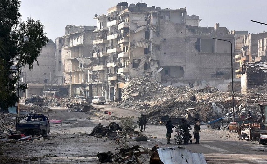 TOPSHOT - Syrian regime forces stand near destruction in the former rebel-held Sukkari district in the northern city of Aleppo on December 23, 2016 after Syrian government forces retook control of the whole embattled city.
Syrian troops cemented their hold on Aleppo after retaking full control of the city, as residents anxious to return to their homes moved through its ruined streets. / AFP / George OURFALIAN (Photo credit should read GEORGE OURFALIAN/AFP/Getty Images)