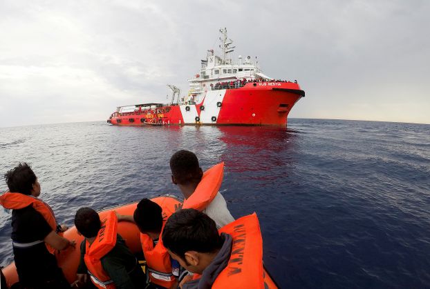 FILE PHOTO - Migrants rescued by "Save the Children" NGO crew approach the ship Vos Hestia in the Mediterranean sea off Libya coast, June 18, 2017. REUTERS/Stefano Rellandini/File photo