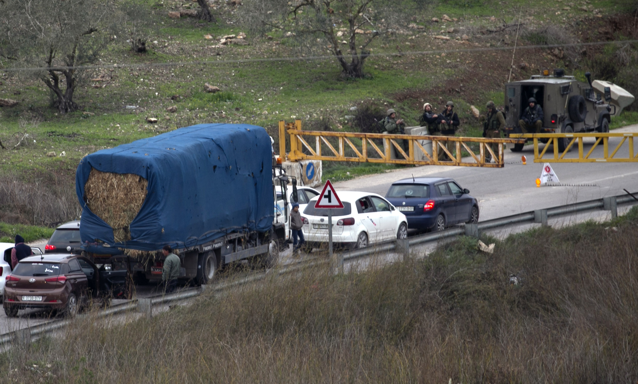 Israeli forces man a roadblock on January 10, 2018 in the area where a 35-year-old Israeli rabbi was killed late the previous day while driving near the wildcat settlement where he lived, around the West Bank village of Jit near Nablus. Israeli forces set up roadblocks and deployed around a major Palestinian city in the occupied West Bank in a manhunt for a gunman who shot dead an Israeli settler. Raziel Shevah. Some 22 gunshots were found in his car, Israel's army radio reported. The gunshots reportedly came from a passing vehicle. / AFP PHOTO / JAAFAR ASHTIYEH