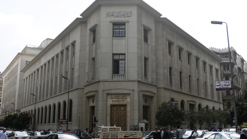 People and vehicles are seen caught in a traffic jam in front of the Central Bank of Egypt's headquarters in downtown Cairo March 17, 2013. Egypt's central bank opened a scheme on Sunday allowing foreign investors in the stock and government debt markets access to dollars despite severe shortages of foreign currency. REUTERS/Amr Abdallah Dalsh (EGYPT - Tags: POLITICS BUSINESS) - RTR3F48W