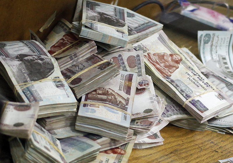 Stacks of money are pictured as an employee counts them at a bank in Cairo September 4, 2014. REUTERS/Asmaa Waguih (EGYPT - Tags: BUSINESS) - RTR44YCY