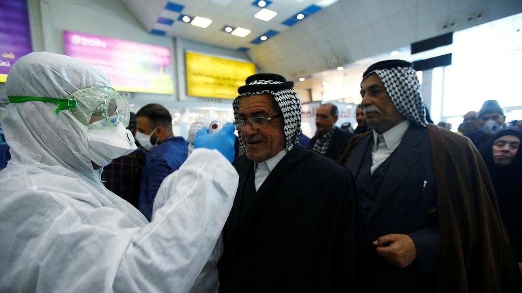 An Iraqi medical staff checks passengers' temperature, amid the new coronavirus outbreak, upon their arrival at Najaf airport, Iraq February 21, 2020. REUTERS/Alaa al-Marjani
