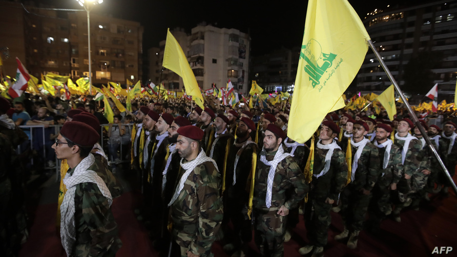 Fighters with the Lebanese Shiite Hezbollah party, carry flags as they parade in a southern suburb of the capital Beirut, to mark the al-Quds (Jerusalem) International Day, on May 31, 2019. - An initiative started by the late Iranian revolutionary leader Ayatollah Ruhollah Khomeini, Quds Day is held annually on the last Friday of the Muslim fasting month of Ramadan and calls for Jerusalem to be returned to the Palestinians. (Photo by Anwar AMRO / AFP)