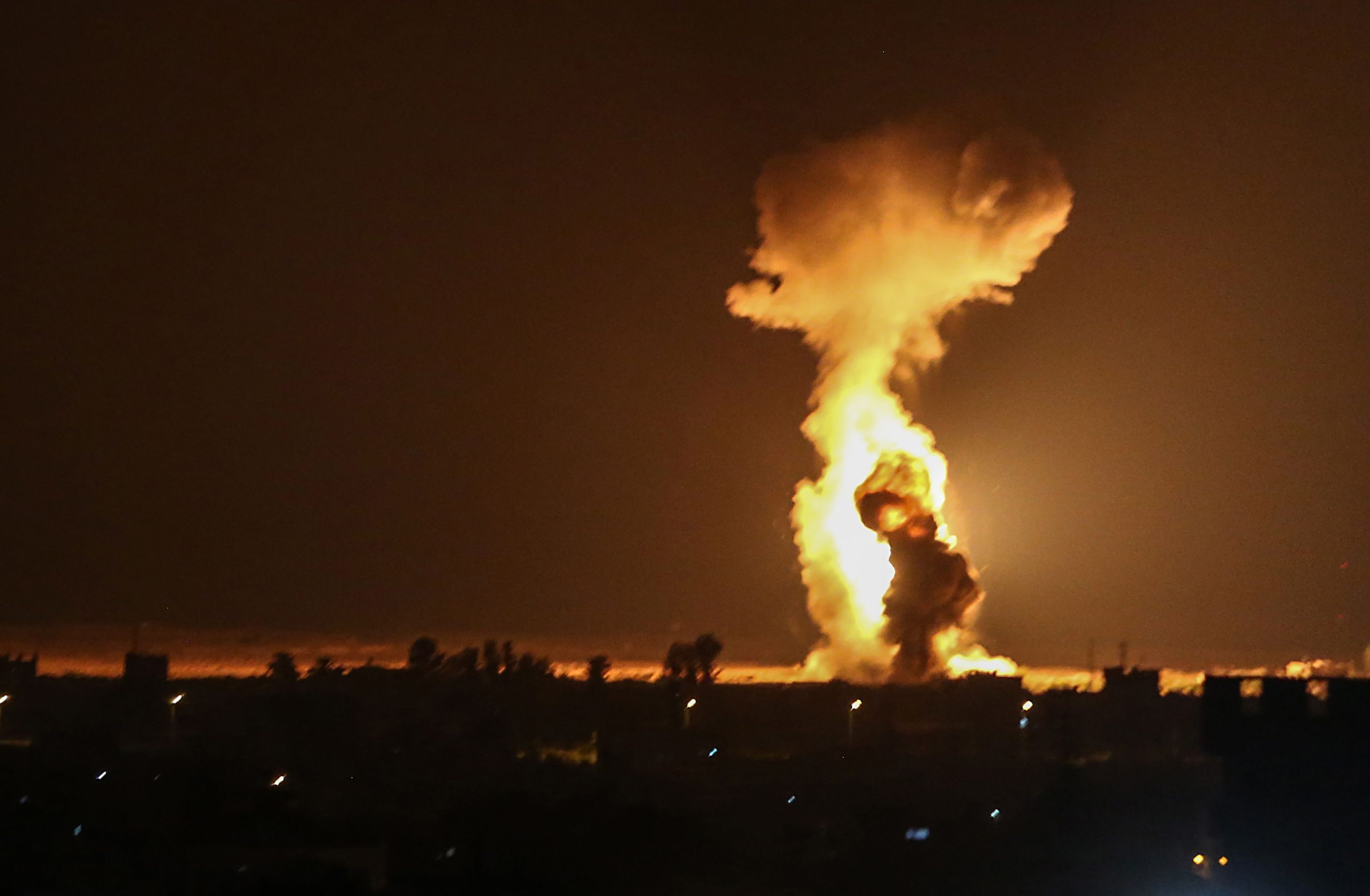 Smoke and flames rise after war planes belonging to the Israeli army carried out airstrikes over the southern Gaza Strip city of Rafah on August 12, 2020. (Photo by SAID KHATIB / AFP)
